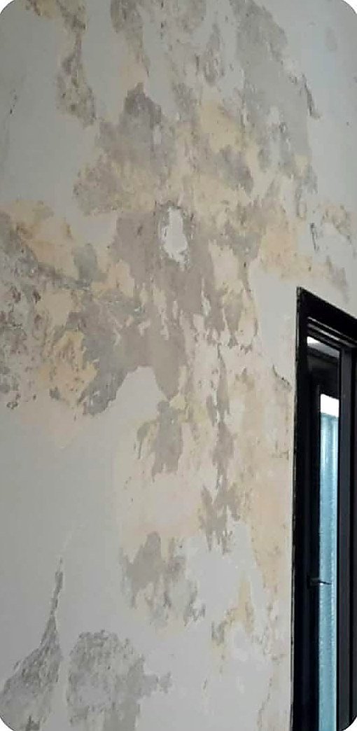 The same hallway wall before, with cracked and flaking plaster