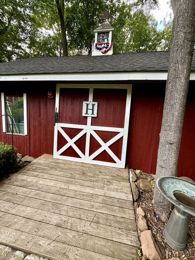 Barn doors repainted with white cross-bracing against red siding