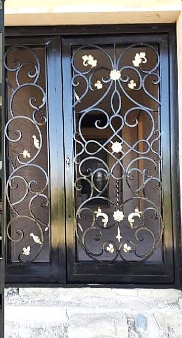 Ornate wrought-iron entry door refinished in black with gold accents
