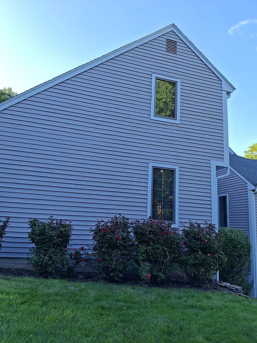 The same gable after repainting by DDP, clean siding and crisp white trim