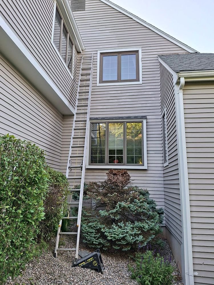 Large home mid-repaint with siding and trim prepped